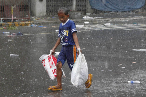 A boy carries relief goods after super Typhoon Haiyan battered Tacloban city