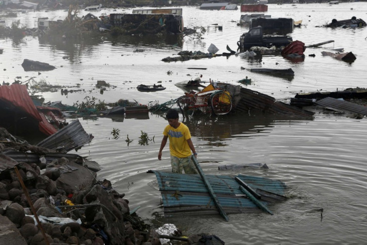A man retrieves a house roofing from a river after Super Typhoon Haiyan battered Tacloban city in central Philippines