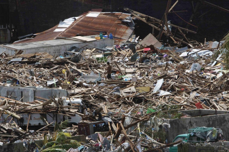 A survivor walks on debris of houses destroyed by Haiyan