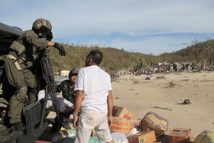 Members of Tactical Operations Group of Philippine Air Force unload relief goods to isolated residents after Typhoon Haiyan hit village in Panay island