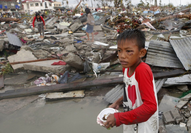 Residents gather coins and other salvageable materials from the ruins of houses after Super Typhoon Haiyan destroyed Tacloban city in central Philippines