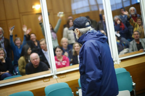 supporters wave to defendant Christian Gauger (front) as he arrives for the start of his trial on charges related to arson and bombing attacks in the late 1970s
