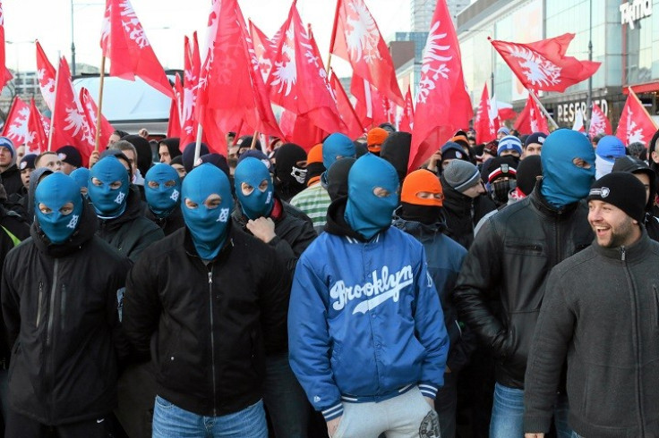 Far-right protesters march with faces covered during their annual march (Reuters)
