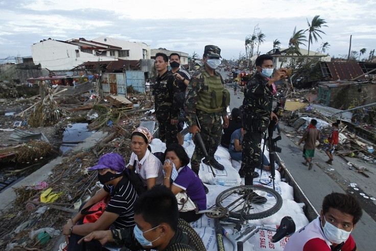 Soldiers and survivors of Typhoon Haiyan survey damage in Talcoban PIC: Reuters