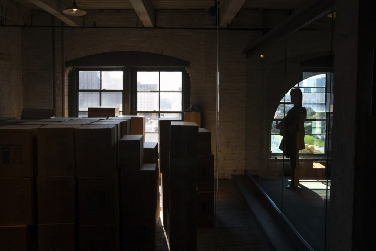 A woman looks toward an enclosed area on the sixth floor of The Sixth Floor Museum at Dealey Plaza