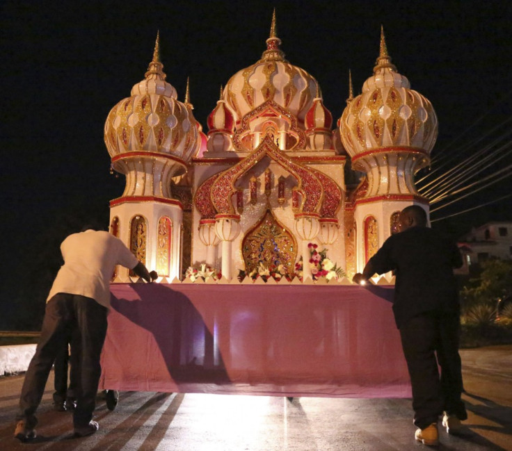 Participants push a "tadjah", a multi-colored mausoleum model paraded as a float, during Ashura in Trinidad and Tobago. (Photo: REUTERS/Andrea De Silva)