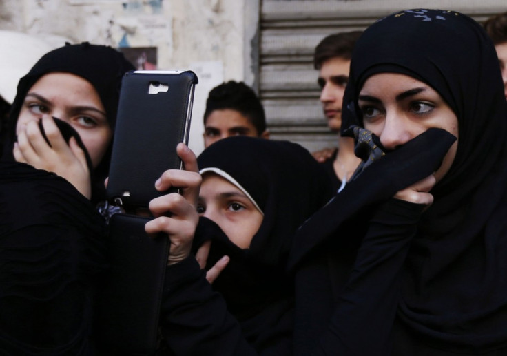 Lebanese women cover their noses as a girl next to them takes pictures of a Muharram procession to mark Ashura in Beirut. (Photo: REUTERS/Jamal Saidi)