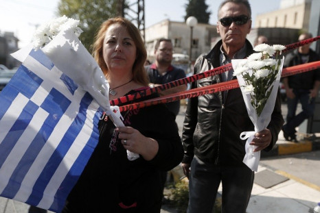 Mourners stand outside Golden Dawn’s Athens office, where two members of the far-right group were shot in November. (Reuters)