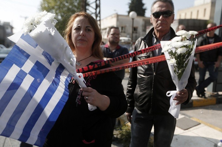 Mourners stand outside Golden Dawn’s Athens office, where two members of the far-right group were shot in November. (Reuters)
