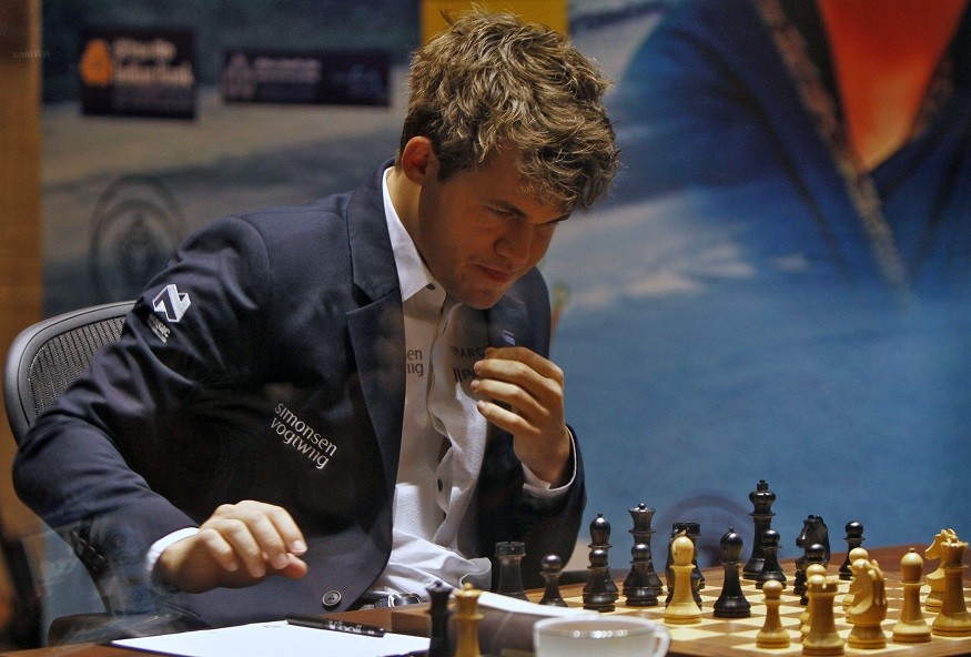 Carlsen reaches ponders his move against Viswanathan Anand during the FIDE World Chess Championship