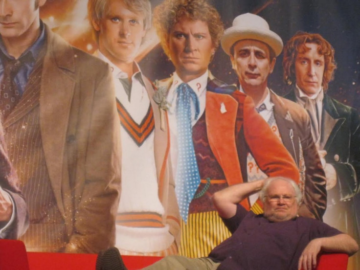 Colin Baker sits in front of a picture of him as The Doctor for the Doctor Who 50th Anniversary celebration (Photo: Lianna Brinded, IBTimes UK)