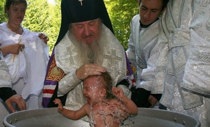 An Orthodox priest baptises a baby in Russia (Reuters)
