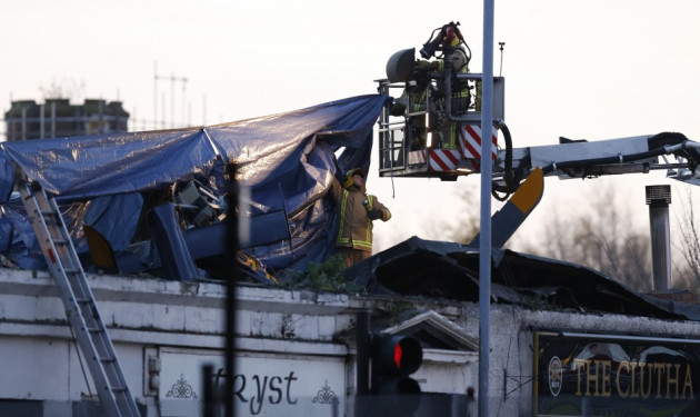 Rescue workers cover the wreckage of a police helicopter which crashed onto the roof of the Clutha Vaults pub in Glasgow, Scotland November 30, 2013. Rescue workers cover the wreckage of a police helicopter which crashed onto the roof of the Clutha Vaults pub in Glasgow, Scotland November 30, 2013.