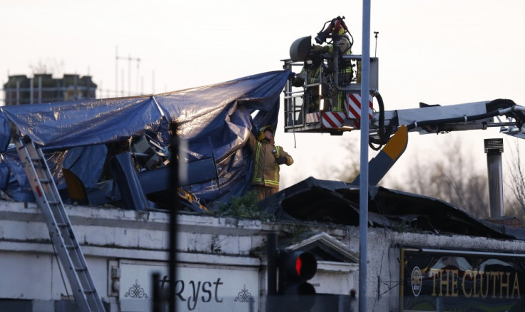 Rescue workers cover the wreckage of a police helicopter which crashed onto the roof of the Clutha Vaults pub in Glasgow, Scotland November 30, 2013.