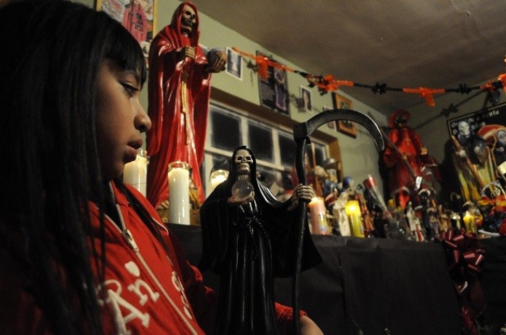 A girl pays homage to Santa Muerte in a shrine in Mexico. (Reuters)