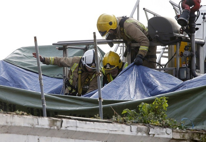 Members of the emergency services use a cherry picker to access the crash site of a police helicopter on the roof of a pub in the centre of Glasgow (Reuters picture)