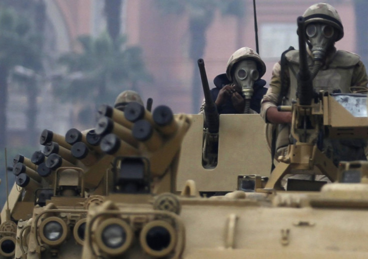 Soldiers riding armoured personnel carriers (APC) arrive at Tahrir Square after clashes with pro-Mursi protesters in Cairo