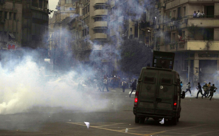 Supporters of the Muslim Brotherhood and ousted Egyptian President Mohamed Mursi flee teargas fired by riot police at Tahrir Square in Cairo