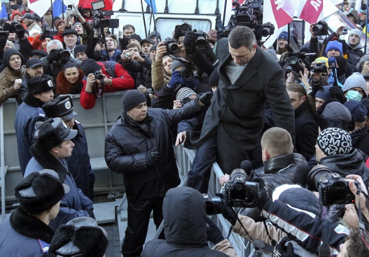 Heavyweight boxing champion and UDAR (Punch) party leader Vitaly Klitschko (top R) climbs over a police fence during a rally in support of EU integration in front of the Ukrainian cabinet of ministers building in Kiev