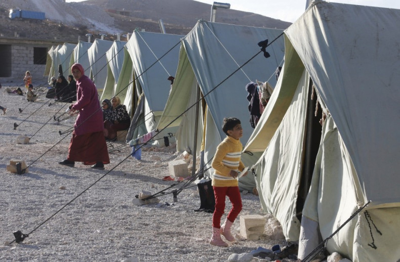 Syrian refugees are seen outside their tents set up by the U.N. at the Lebanese border town of Arsal, in the eastern Bekaa Valley