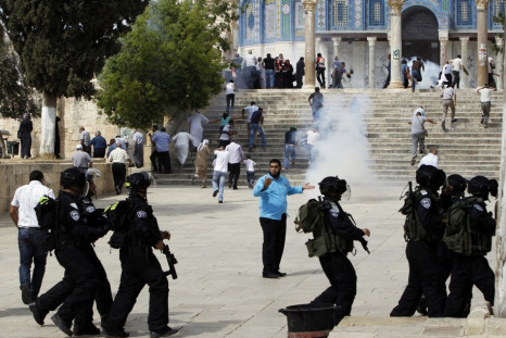 Muslim worshippers run as tear gas fired by Israeli policemen rises during clashes