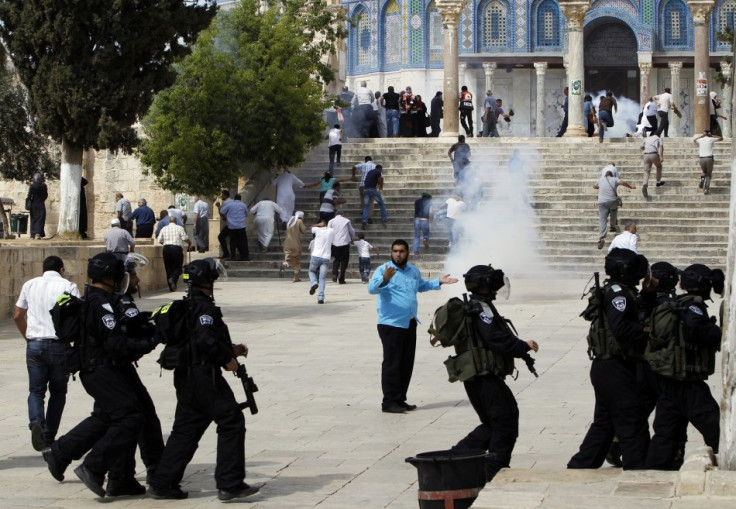 Muslim worshippers run as tear gas fired by Israeli policemen rises during clashes