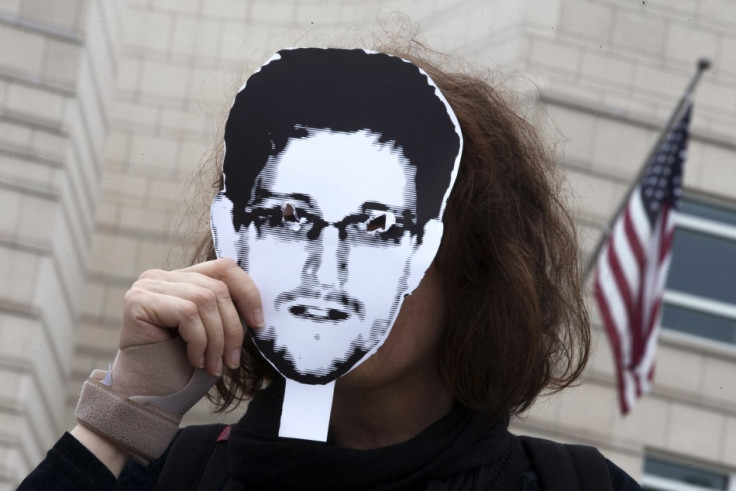 Woman holds a portrait of former U.S. spy agency contractor Snowden in front of her face as she stands in front of the U.S. embassy during a protest in Berlin in this file photo