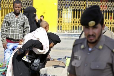 An Ethiopian worker carries her baby as she waits with her countrymen to be repatriated in Manfouha, southern Riyadh