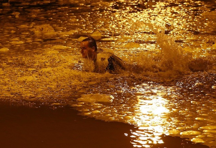 A man falls in flood water during the storm surge in Great Yarmouth (Reuters)