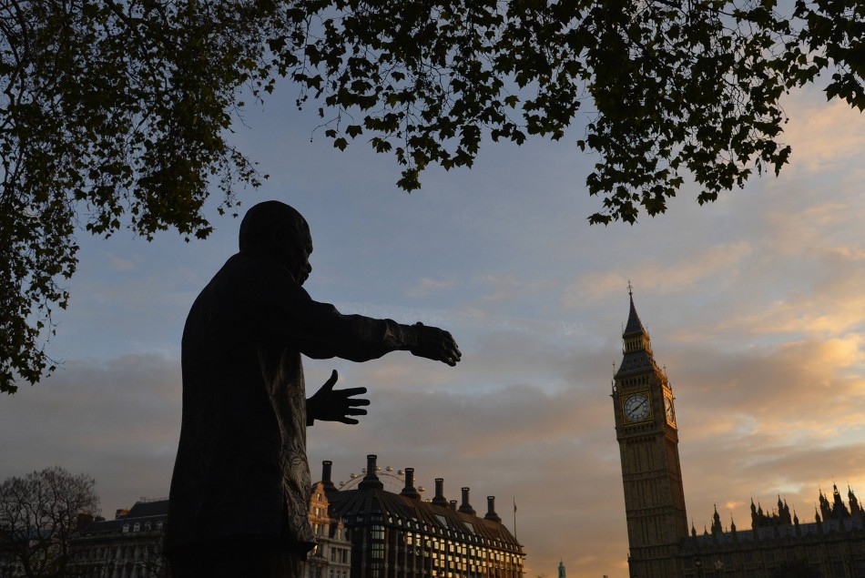 A statue of former South African President Nelson Mandela is seen with the Big Ben clock and the Houses of Parliament in the background at dawn in London December 6, 2013.
