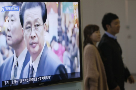 A couple walks past a television showing a report on Jang Song Thaek, North Korean leaders' uncle, at a railway station in Seoul