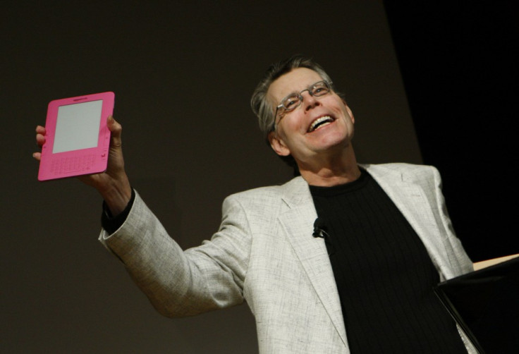 Author Stephen King holds up a pink Amazon Kindle 2 electronic reader.