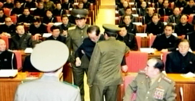 Jang being taken away by uniformed guards