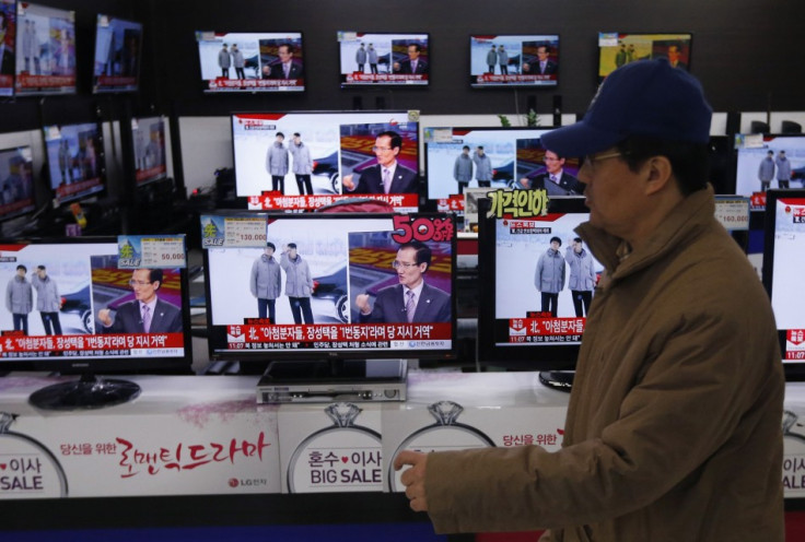A man walks past televisions showing reports on the execution of Jang Song Thaek at an electronic store in Seoul December 13, 2013. (Reuters)