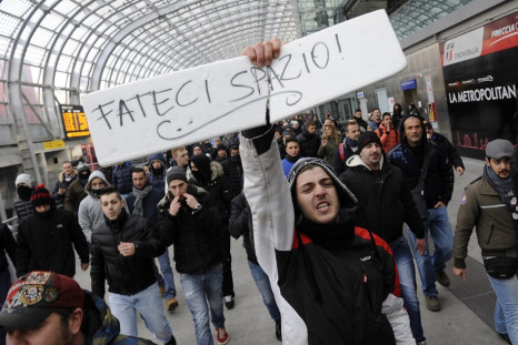 A protester holds a sign that reads "Make room for us" during a protest at the Turin train station