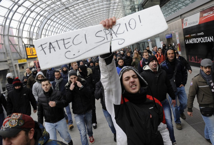 A protester holds a sign that reads "Make room for us" during a protest at the Turin train station