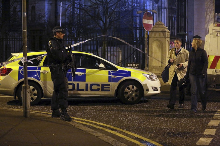 An armed policeman speaks to a member of the public near the scene of an explosion in Belfast's Cathedral Quarter