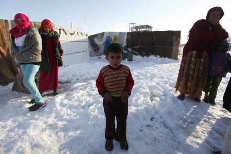 A child refugee from the northern province of Raqqa in Syria, reacts from the cold weather in a Syrian refugee camp beside the Lebanese border town of Arsal, in eastern Bekaa Valley