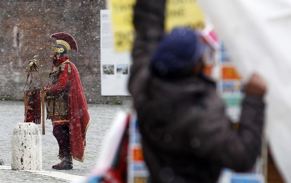A man dressed as a centurion outside Rome's Colosseum in the December snow.