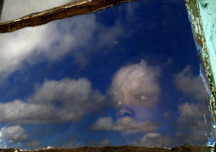 A local boy, Anda, looks out from his huts window at the burial ground of late former South African President Nelson Mandela ahead of his funeral in Qunu, December 15, 2013. Reuters picture
