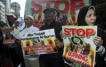 Indonesian pluralist campaigners hold placards in their call to stop a planned burning of the Muslim's Holy Koran in Florida, Jakarta