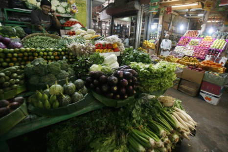A vegetable seller speaks on a mobile phone at a market in Kolkata February 25, 2010.