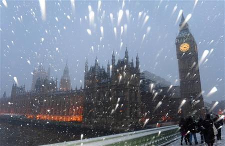 Snow falls around The Houses of Parliament in central London
