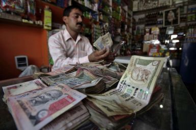 A shopkeeper counts Indian currency notes inside his shop in Jammu July 14, 2010.