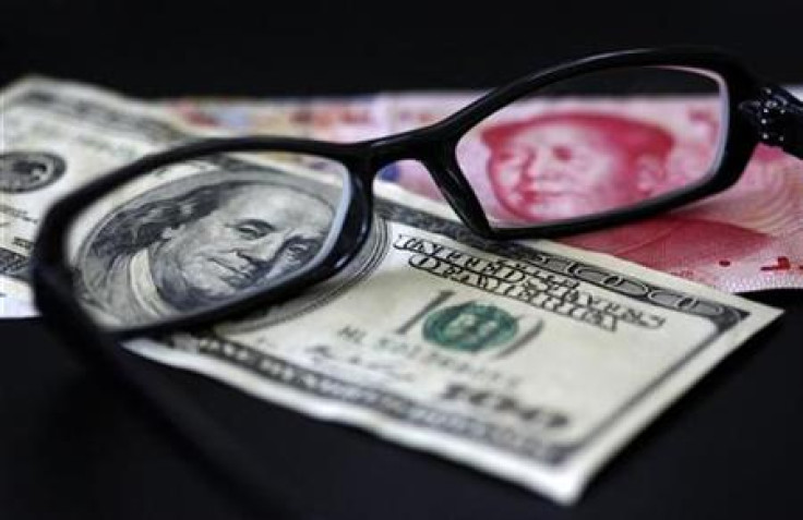 A U.S. dollar note and a Chinese yuan banknote are seen through a pair of spectacles in this picture illustration taken in Taipei
