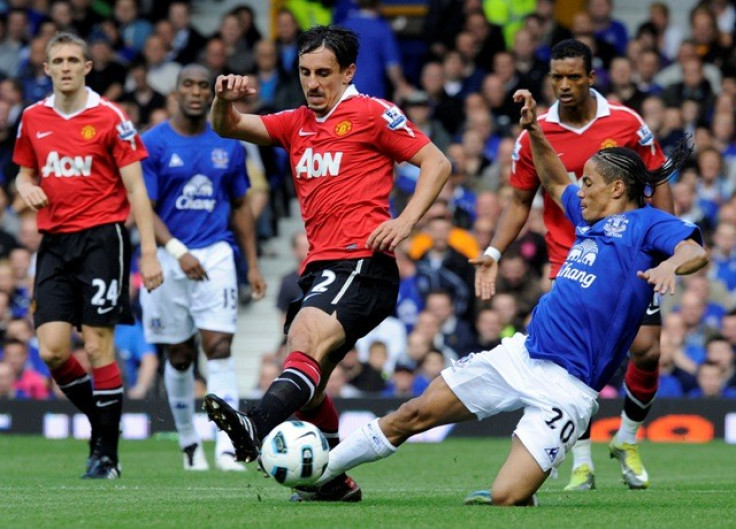 Everton's Pienaar challenges Manchester United's Neville during their English Premier League soccer match in Liverpool.
