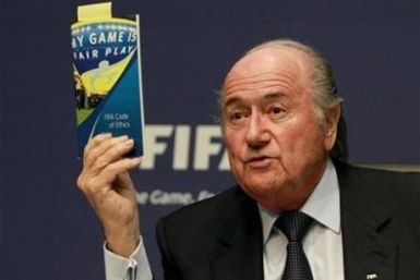 FIFA President Sepp Blatter displays a brochure containing the FIFA code of ethics as he addresses a news conference at the FIFA headquarters in Zurich October 29, 2010.