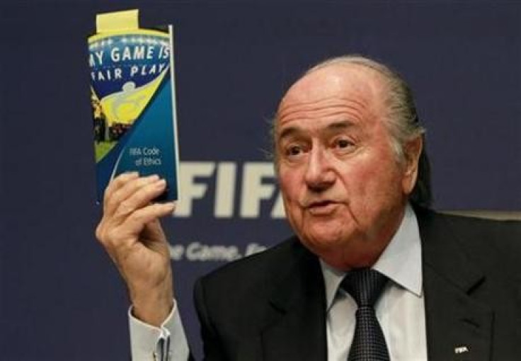 FIFA President Sepp Blatter displays a brochure containing the FIFA code of ethics as he addresses a news conference at the FIFA headquarters in Zurich October 29, 2010.