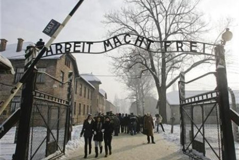People walk through the gate, with the words "Arbeit macht frei" (Work sets you free), of the former Nazi death camp of Auschwitz in Oswiecim