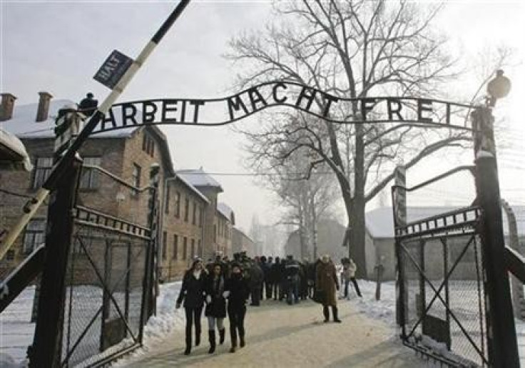 People walk through the gate, with the words &quot;Arbeit macht frei&quot; (Work sets you free), of the former Nazi death camp of Auschwitz in Oswiecim